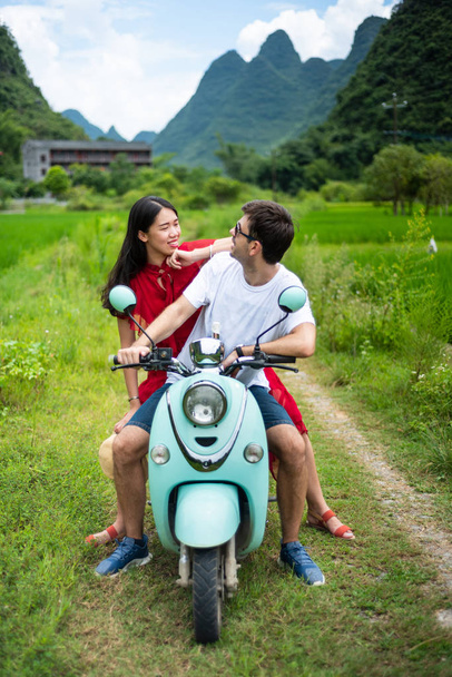 Пара веселится на мотоцикле вокруг рисовых полей Яншо, Китай
 - Фото, изображение
