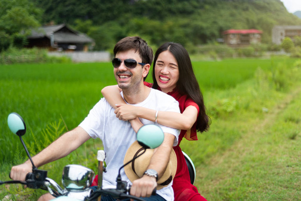 Пара веселится на мотоцикле вокруг рисовых полей Яншо, Китай
 - Фото, изображение