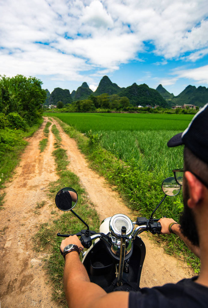 Male traveler riding motorbike on Asian trip - 写真・画像