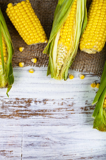Ripe yellow corn  on a wooden table. - Foto, imagen