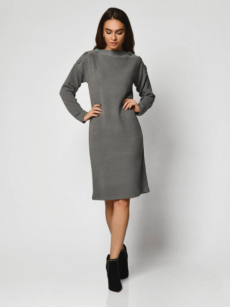 Young beautiful woman posing in new gray fashion winter dress full body - Foto, imagen