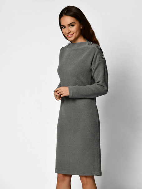 Young beautiful woman posing in new gray fashion winter dress full body - Фото, зображення