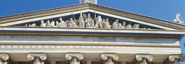 Vista panorámica de esculturas de dioses y ornamentos dorados en la icónica Academia de Atenas, Grecia
 - Foto, imagen