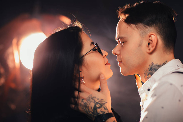 portrait couple in fashionable clothes on a dark smoky background. - Photo, Image