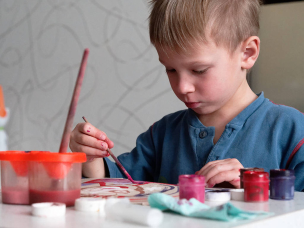 dítě chlapec s nadšením maluje akvarely na papíře - Fotografie, Obrázek