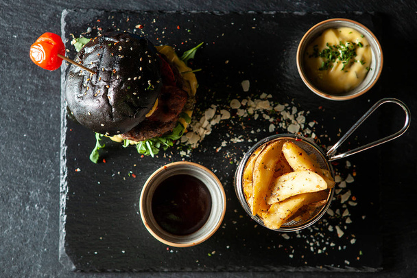 Delicioso hambúrguer de carne preta com soia sos e batatas fritas
 - Foto, Imagem