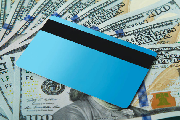 Tarjeta de crédito azul se encuentra en los billetes de fondo dólares estadounidenses. Copiar espacio
. - Foto, Imagen