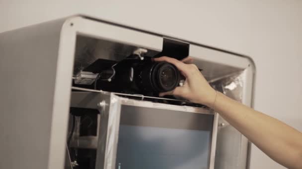 Kadının ayarı lense odasında büyük bir kutu içine yerleştirilen siyah fotoğraf makinesinin el. - Video, Çekim