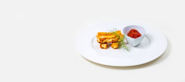 Fried halloumi and tomato dip on a white plate on a white background - Photo, Image
