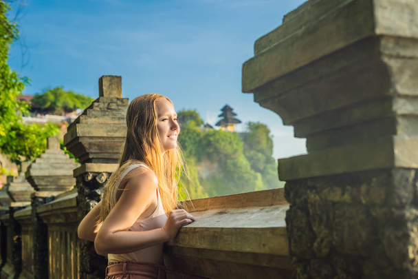 Young woman enjoying view from Pura Luhur Uluwatu temple, Bali, Indonesia of amazing landscape with cliff and sea. - Φωτογραφία, εικόνα