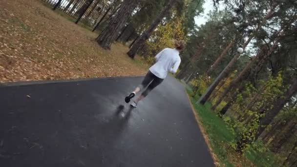 Sportliche junge Frau läuft im Herbstpark. - Filmmaterial, Video