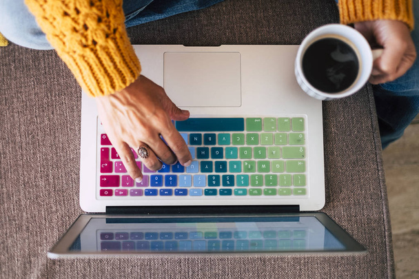 Top kilátás a női kéz dolgozik egy laptop otthon fekete kávé  - Fotó, kép