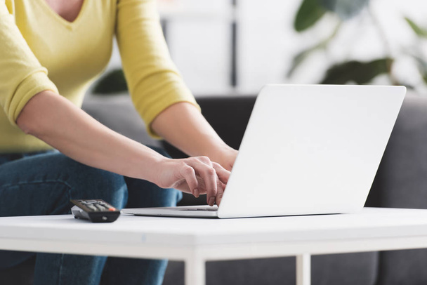 cropped shot of woman sitting on couch and using laptop - Photo, Image