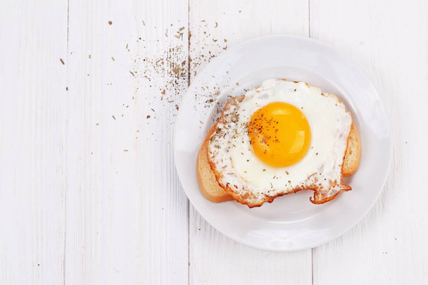 Fried eggs on a slice of white bread with spices - Fotoğraf, Görsel