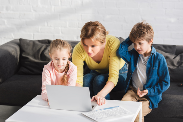 mother with adorable children using laptop together at home  - Valokuva, kuva