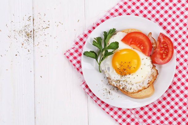 Fried eggs on a slice of white bread with tomatoes and parsley - Foto, Imagem
