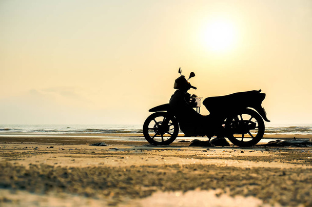 Silueta de moto una moto se para en la playa
 - Foto, Imagen