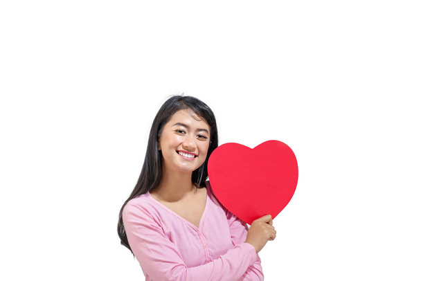 Beautiful asian woman with red heart standing isolated over white background. Valentines day - 写真・画像