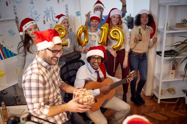  Smiling business workers have fun in Santa hat at Christmas party in office - Photo, Image
