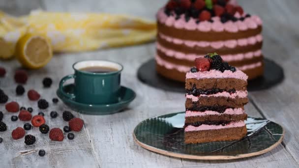 Chocolate cake with summer berries. Piece of chocolate cake with icing and fresh berry. - Materiaali, video