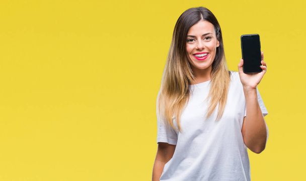 junge schöne Frau zeigt leeren Bildschirm des Smartphones über isoliertem Hintergrund mit einem glücklichen Gesicht stehend und lächelnd mit einem selbstbewussten Lächeln, das Zähne zeigt - Foto, Bild