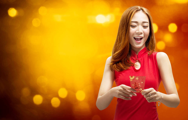 Cheerful chinese woman in traditional dress holding red envelopes. Happy Chinese New Year - Φωτογραφία, εικόνα