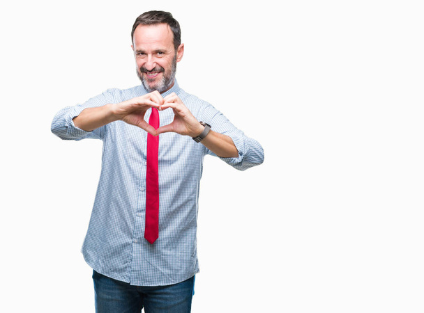 Middle age hoary senior business man wearing red tie over isolated background smiling in love showing heart symbol and shape with hands. Romantic concept. - Fotó, kép