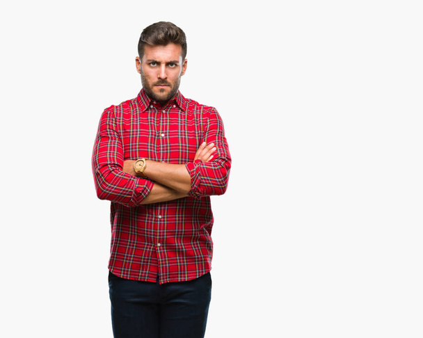 Young handsome man over isolated background skeptic and nervous, disapproving expression on face with crossed arms. Negative person. - Photo, Image