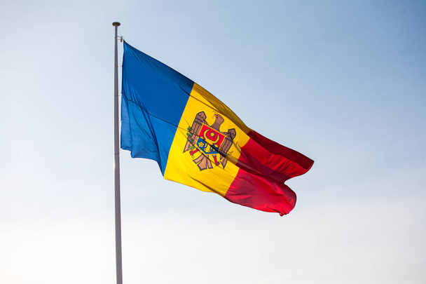 Moldova zászlaja a zászlórúd ellen a kék ég - Fotó, kép