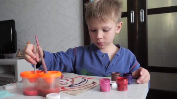 chłopiec dziecko entuzjastycznie maluje akwarele na papierze. - Materiał filmowy, wideo