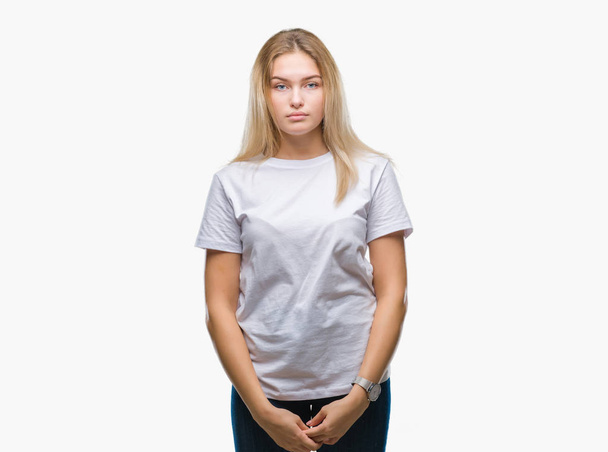 Young caucasian woman over isolated background with serious expression on face. Simple and natural looking at the camera. - Foto, Imagem
