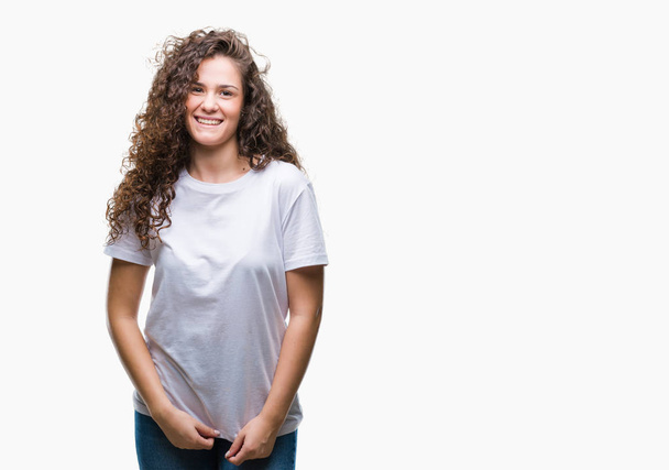 Красивая брюнетка с вьющимися волосами молодая девушка в повседневной футболке на изолированном фоне с счастливой и прохладной улыбкой на лице. Счастливчик
. - Фото, изображение