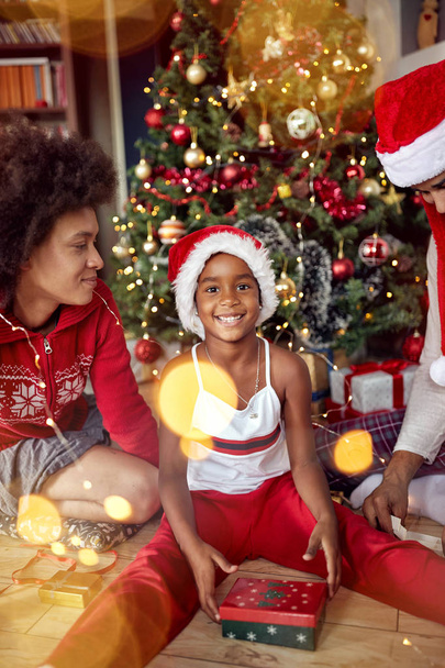 Happy family- Cute girl opens a gift for Christmas morning - Foto, Bild