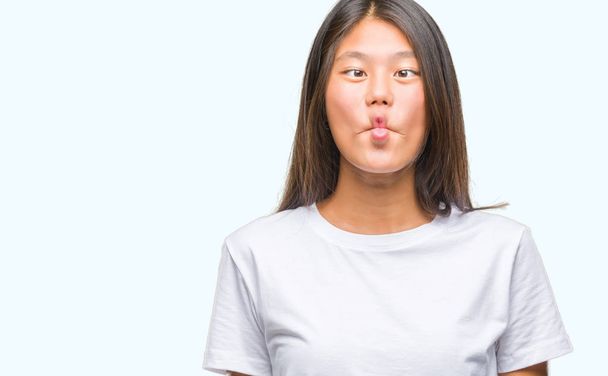 Young asian woman over isolated background making fish face with lips, crazy and comical gesture. Funny expression. - Zdjęcie, obraz