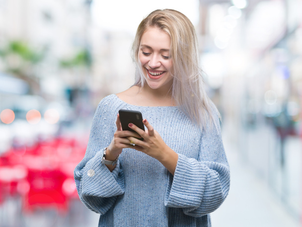 Nuori blondi nainen kutoma lähettää viestin älypuhelimella yli eristetty tausta onnellinen kasvot seisoo ja hymyilee luottavainen hymy osoittaa hampaat
 - Valokuva, kuva