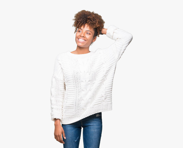 Красива молода жінка афро-американських носити взимку светр над ізольованих фон посміхаючись впевнено зворушлива волосся з боку вгору жестом, Постановка привабливим - Фото, зображення