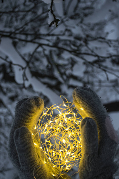 The festoon lights in hands outdoor. - Photo, Image