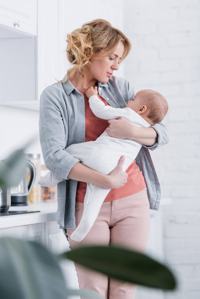 selective focus of mother holding adorable infant child at home  - Φωτογραφία, εικόνα