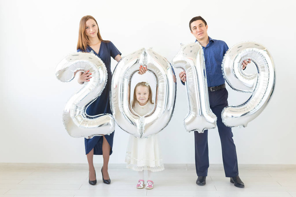 Yeni 2019 yılı önümüzdeki kavramdır - mutlu aile gümüş renkli numaraları kapalı tutuyorsun. - Fotoğraf, Görsel