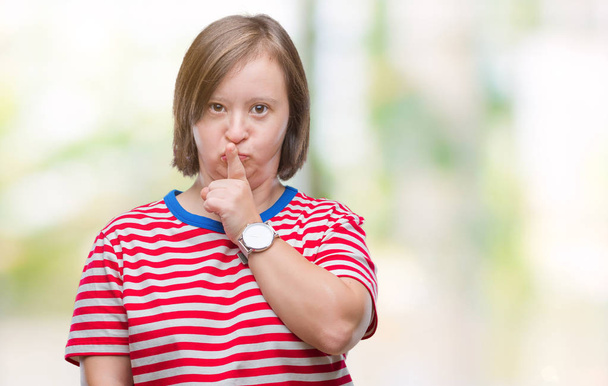 Молода доросла жінка з синдромом Дауна просить мовчати з пальцем на губах
 - Фото, зображення