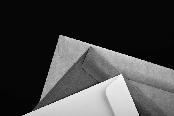 Photo of blank envelopes on a black background. Template for branding identity. Envelopes mockup. White paper isolated on black. Top view. - Valokuva, kuva