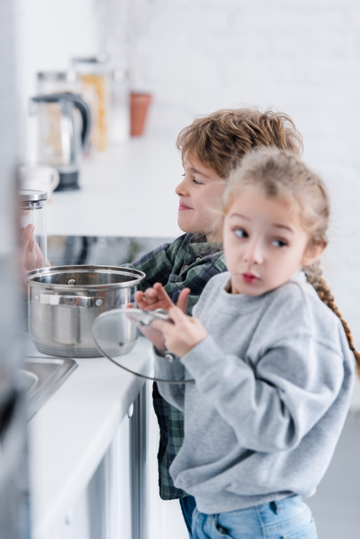 adorable brother and sister washing pan in kitchen - Zdjęcie, obraz