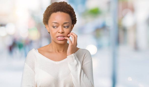 Young african american woman over isolated background looking stressed and nervous with hands on mouth biting nails. Anxiety problem. - Zdjęcie, obraz