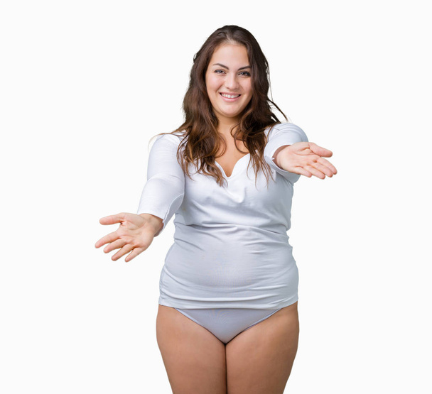 Beautiful plus size young overwight woman wearing white underwear over isolated background looking at the camera smiling with open arms for hug. Cheerful expression embracing happiness. - Photo, Image