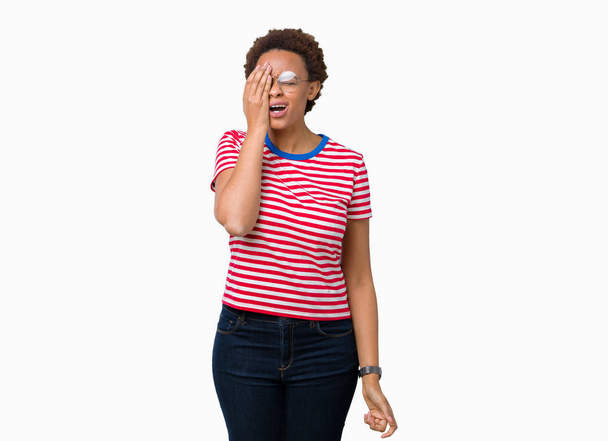 Linda jovem afro-americana vestindo óculos sobre fundo isolado bocejo cansado cobrindo metade do rosto, olho e boca com a mão. Cara dói na dor
. - Foto, Imagem