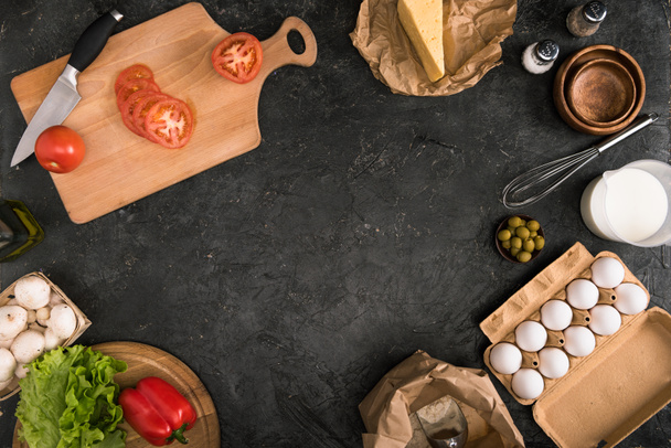 chopped tomatoes on cutting board and pizza ingredients on grey background with copy space - 写真・画像
