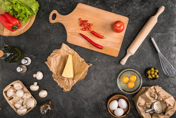 top view of pizza ingredients and cooking utensils on grey background  - Fotó, kép