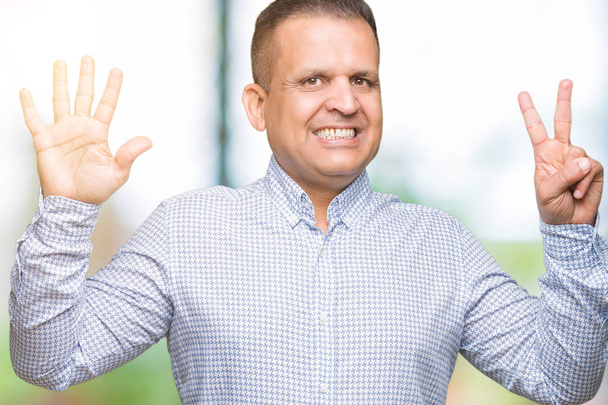Арабський бізнесмен середнього віку над ізольованим тлом, що показує і вказує пальцями номер сім, посміхаючись впевнено і щасливо
. - Фото, зображення
