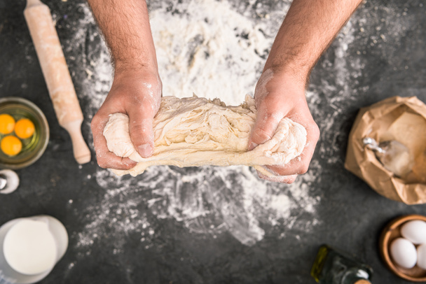 selective focus of man preparing dough on grey background with flour - Zdjęcie, obraz