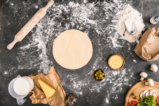 top view of pizza dough with ingredients on grey background - Photo, Image